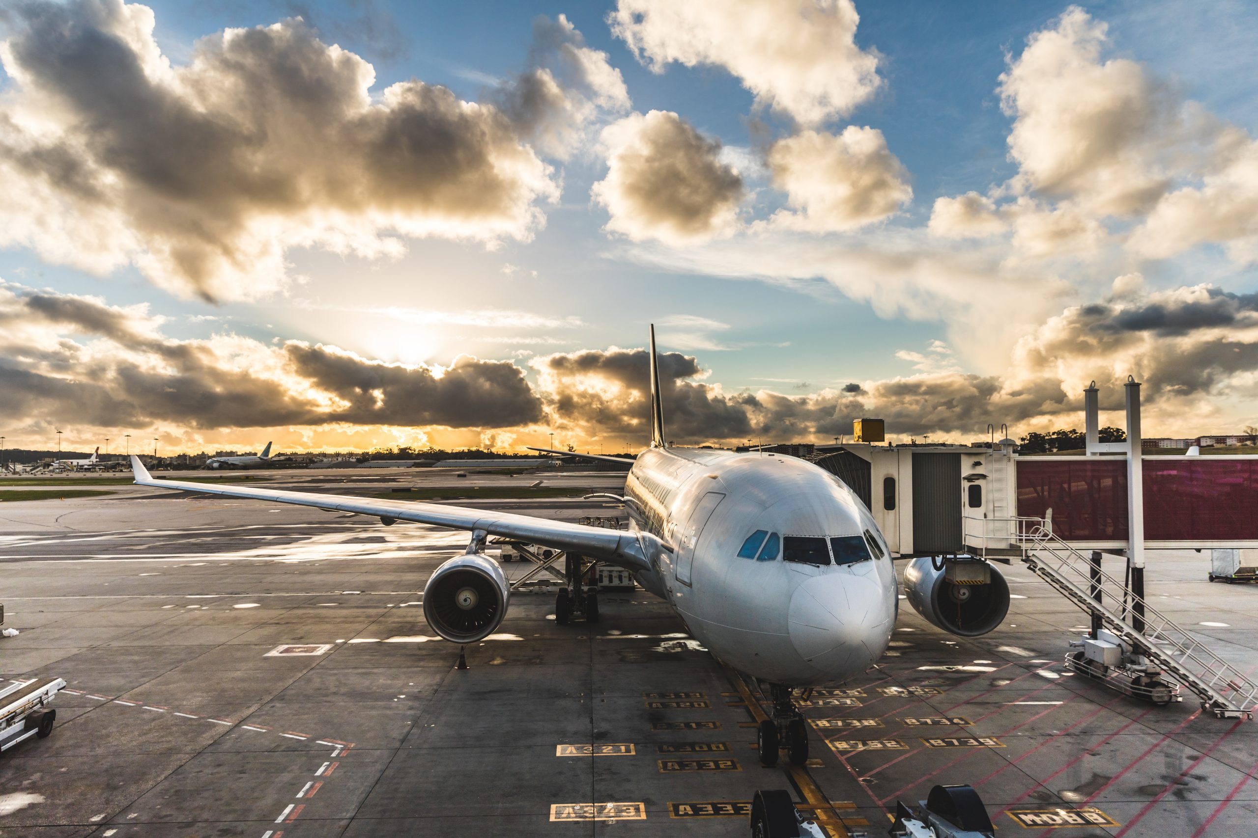 Airplane boarding passengers at airport at sunset